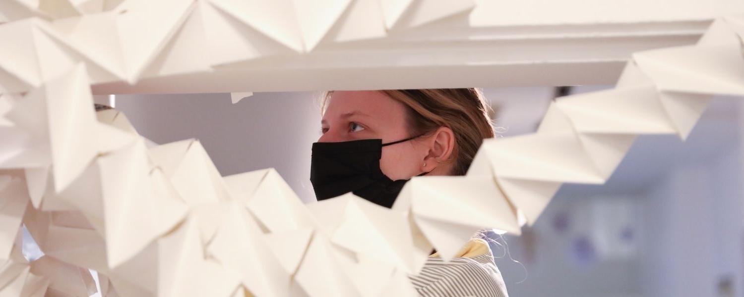 An art student works on a paper project in the 艺术 Center.